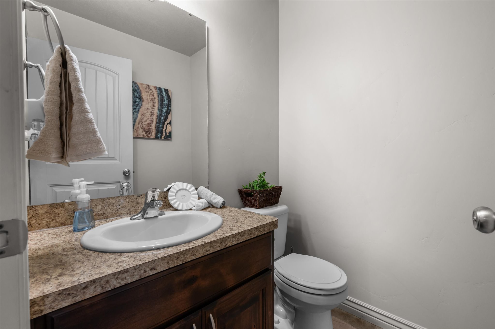 Bathroom featuring a built-in vanity with a speckled countertop, an undermount sink, and a chrome faucet