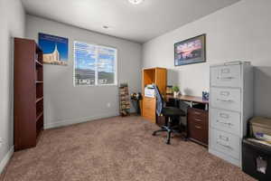 Carpeted room with a ceiling light fixture, a window featuring horizontal blinds, and neutral-toned wall paint