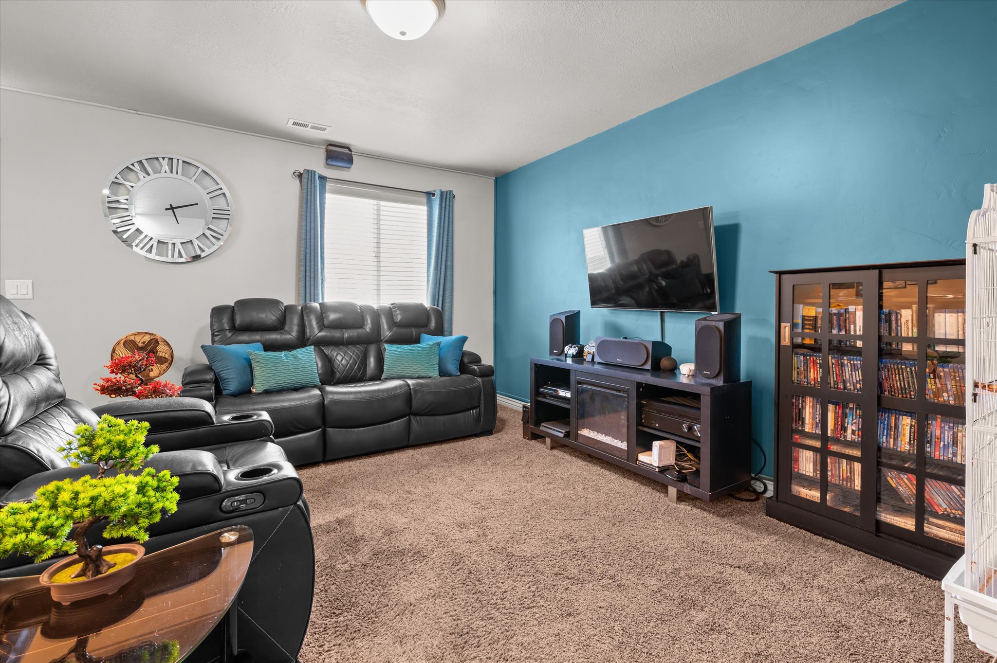 Living area featuring a textured carpet, a distinctive accent wall
