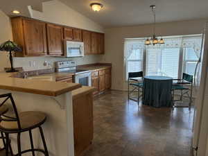 Kitchen featuring wood cabinetry, built-in microwave, and a breakfast bar