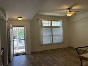 Spacious living area featuring LVP flooring, a multi-pane window with blinds, a storm door and a ceiling fan with integrated lighting