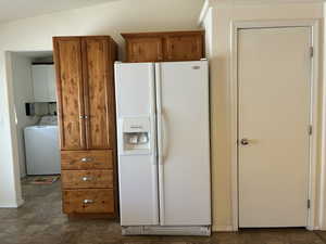 Kitchen area featuring wood-finish cabinetry with silver hardware and a pantry closet