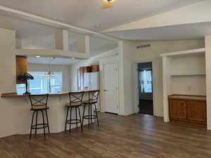 Open-concept living area featuring LVP flooring, a breakfast bar