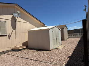 Side yard featuring gravel landscaping and a storage shed and clothes line