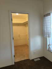 Carpeted closet with built-in shelving and clothing rods