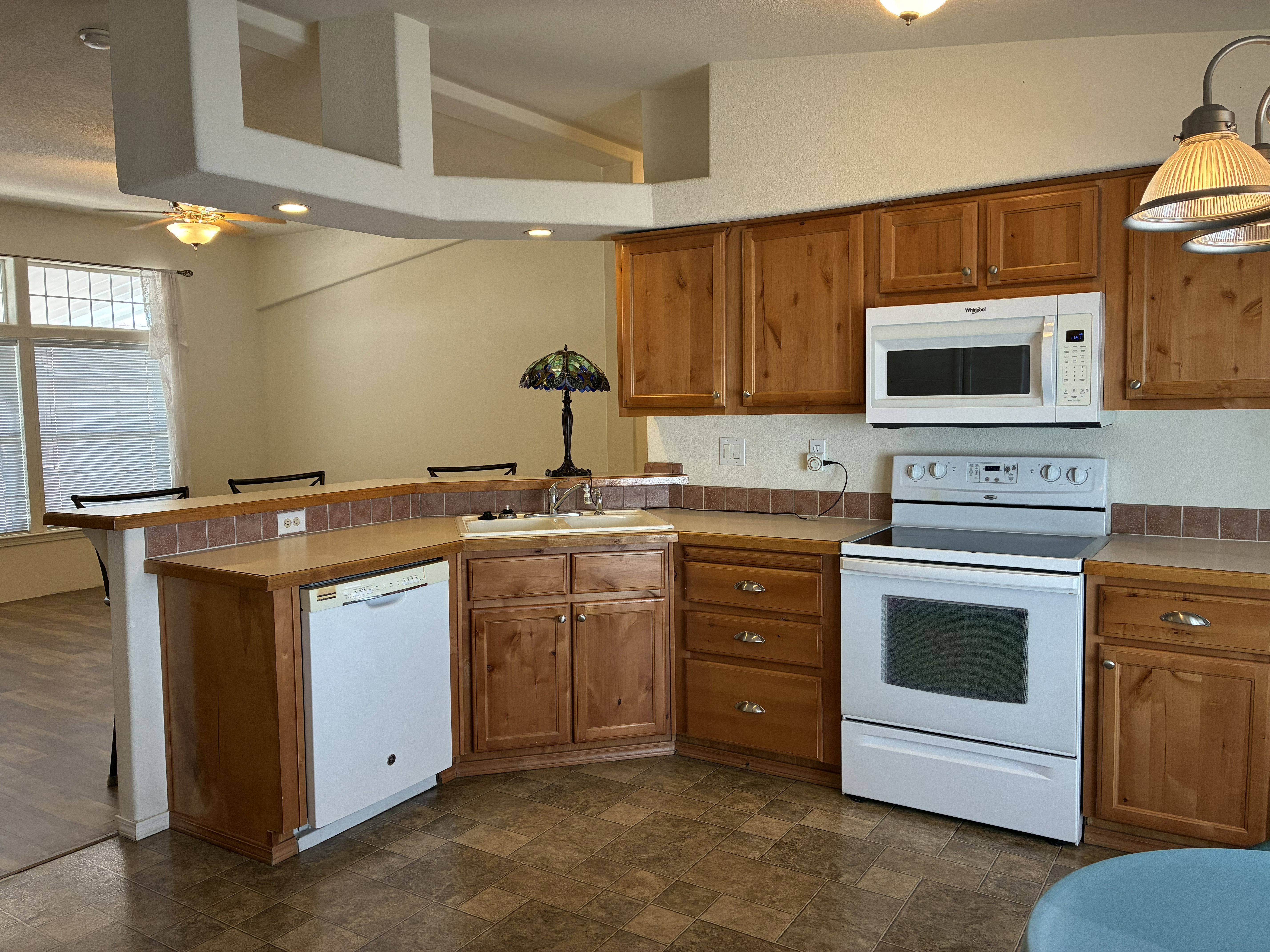 Kitchen featuring wood cabinetry, laminate countertops, and a tile backsplash