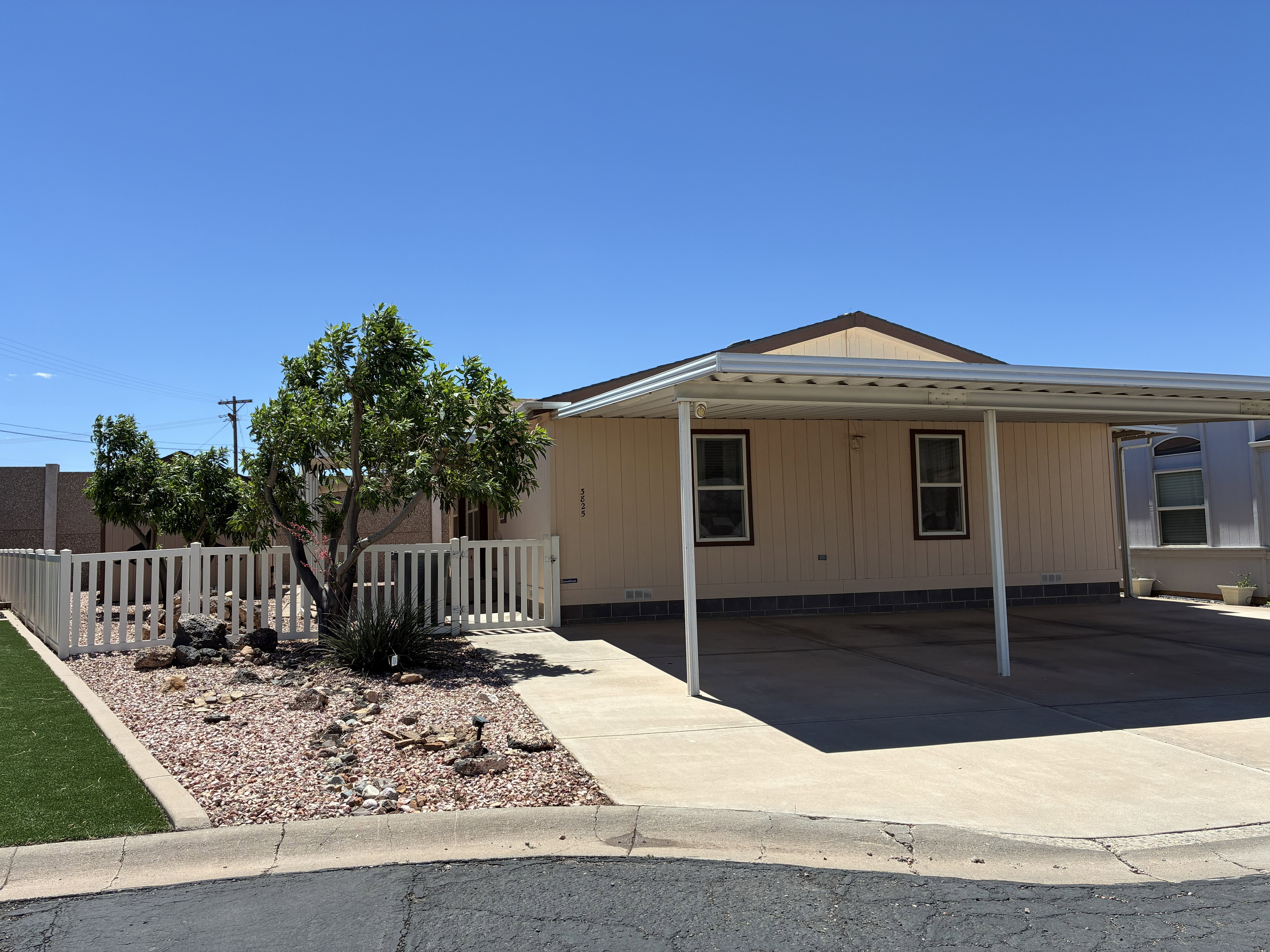 Exterior features a 3-car carport with concrete paving and beautiful landscaping