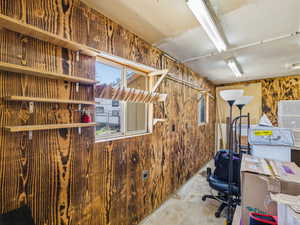 Interior space featuring wood-finish paneling, multiple windows, built-in shelving, and overhead fluorescent lighting