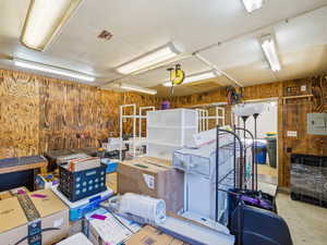 Utility space featuring wood-paneled walls and exposed ceiling beams