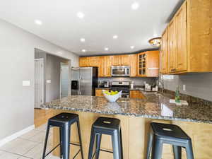 Kitchen featuring light wood cabinetry, granite countertops, and stainless steel appliances