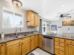 Kitchen featuring wood cabinetry, dark speckled countertops, and stainless steel appliances
