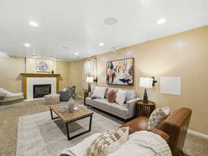 Living area featuring recessed lighting, a built-in fireplace with a hearth and wood mantel, and carpeted flooring