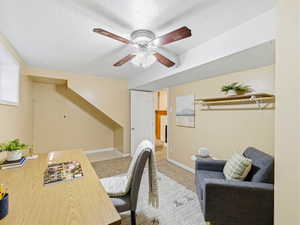 Versatile room featuring a ceiling fan, light-toned walls, and a built-in shelving unit