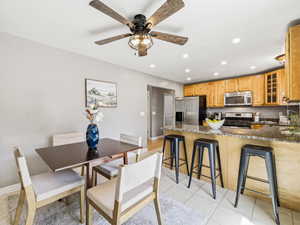 Kitchen featuring wood cabinetry, stainless steel appliances, and an eat-in island with counter seating
