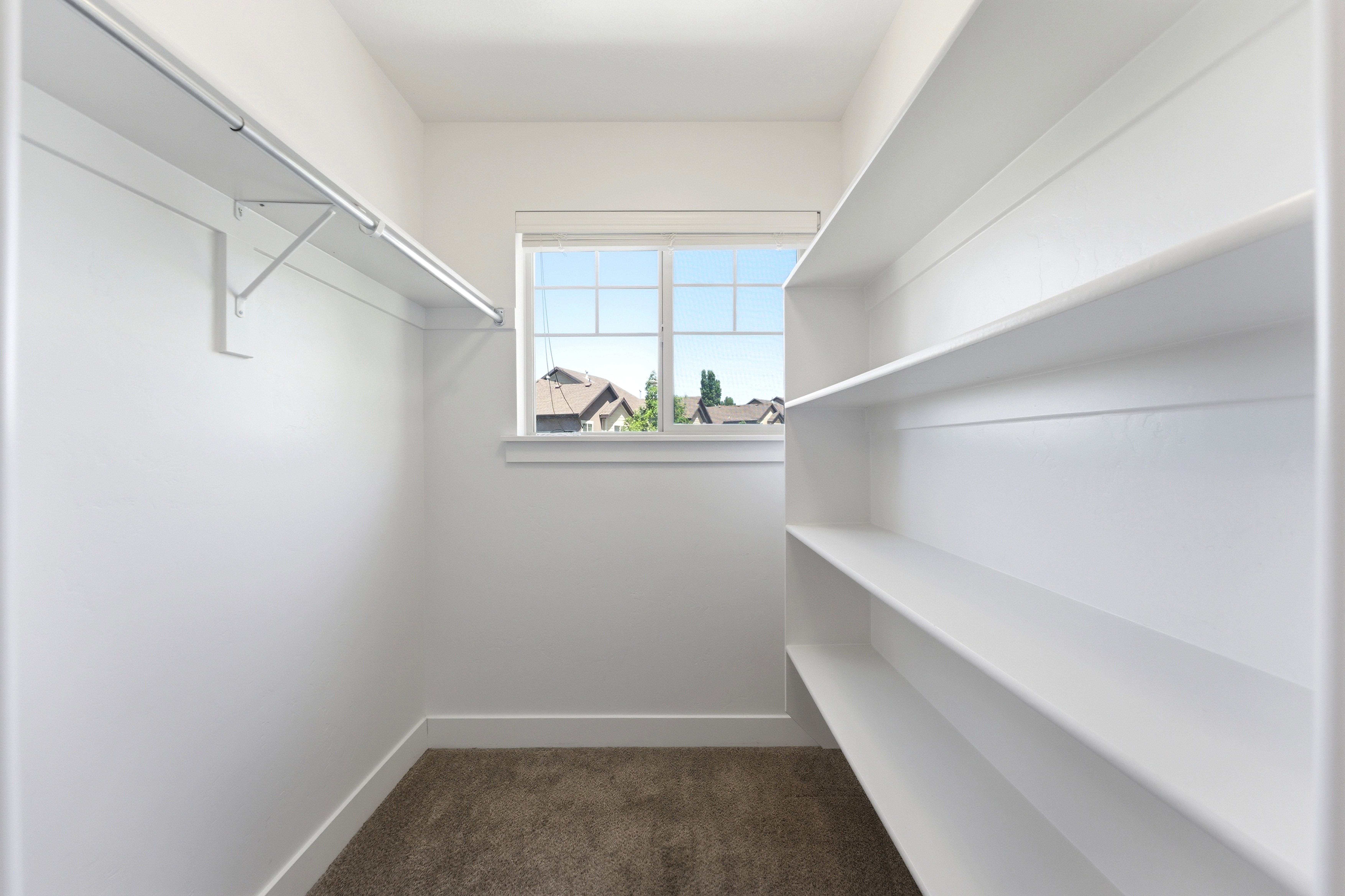 Built-in shelving and hanging rods in a neutral color palette