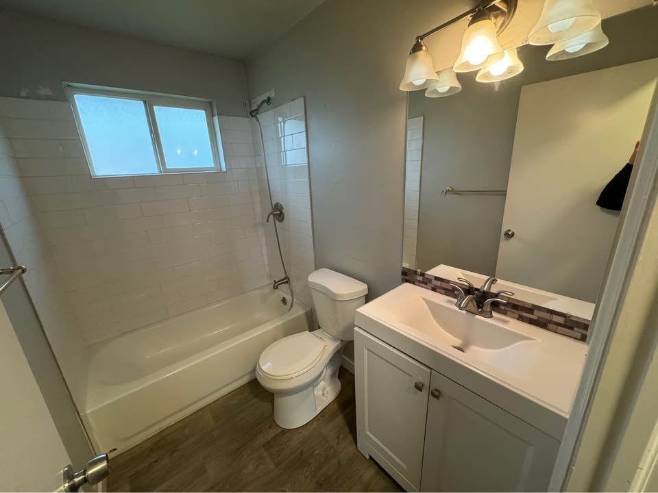 Full bath featuring vanity, shower / washtub combination, and dark wood-style flooring
