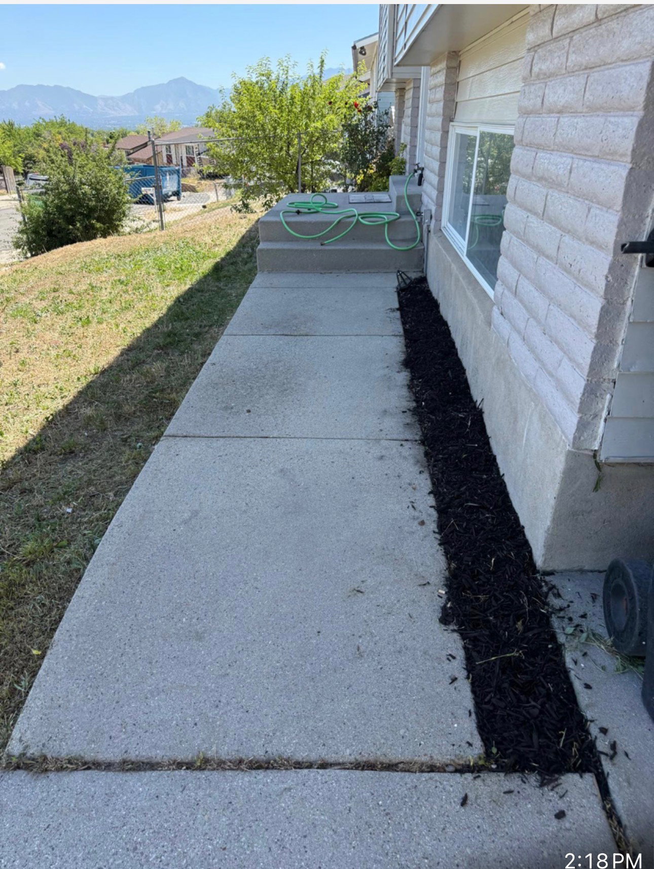 Concrete walkway leading to a two-step concrete entrance