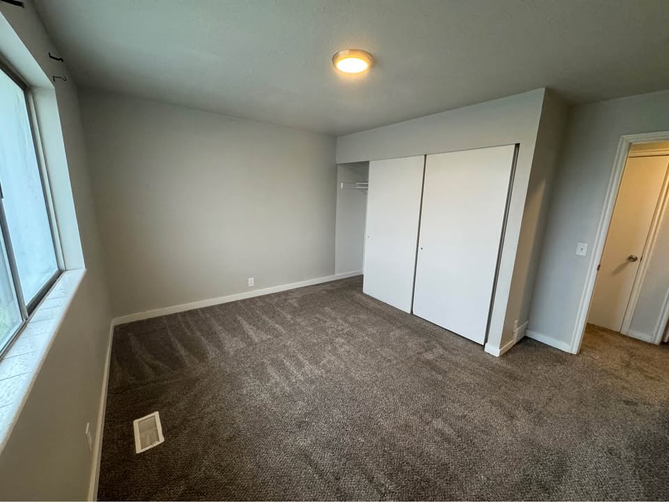Unfurnished bedroom with dark colored carpet and a closet