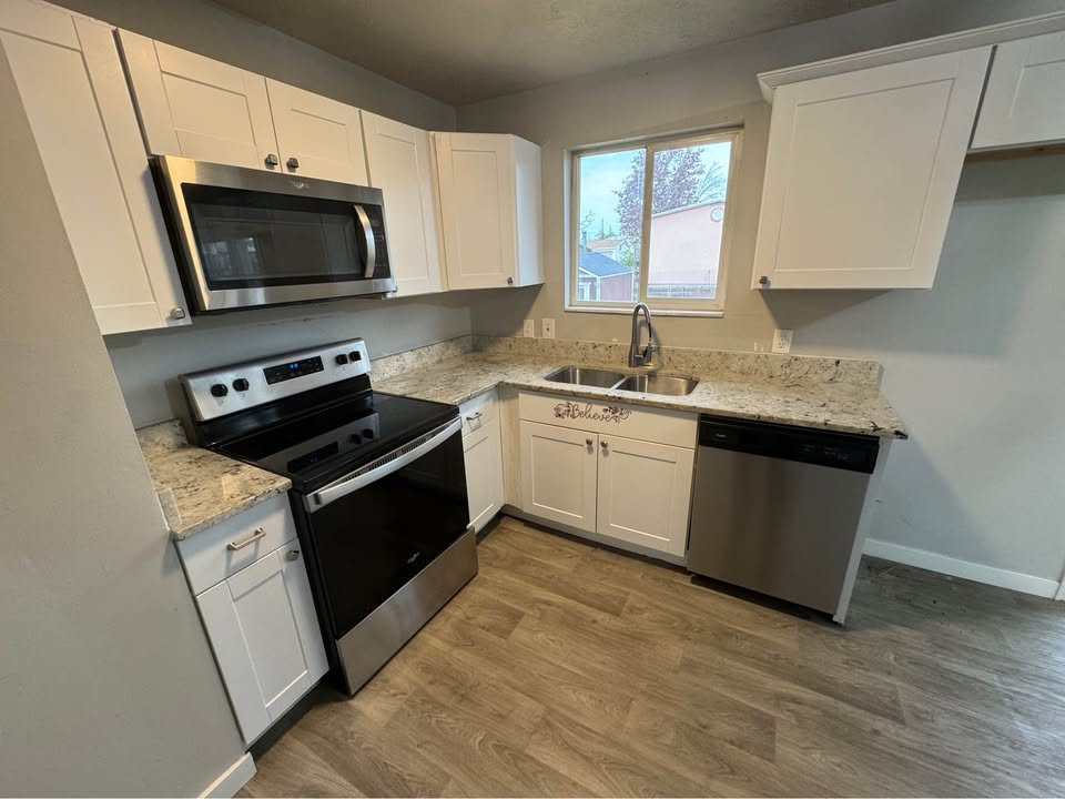 Kitchen featuring stainless steel appliances and white cabinets