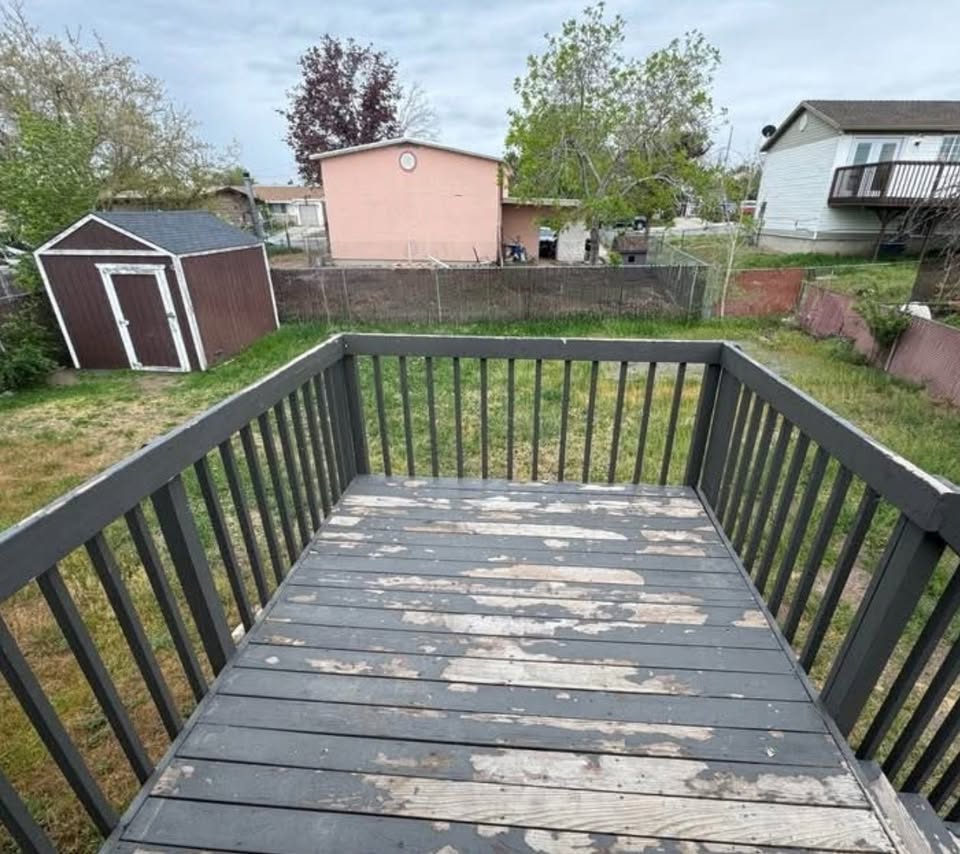 Wooden deck with a fenced backyard and a storage shed