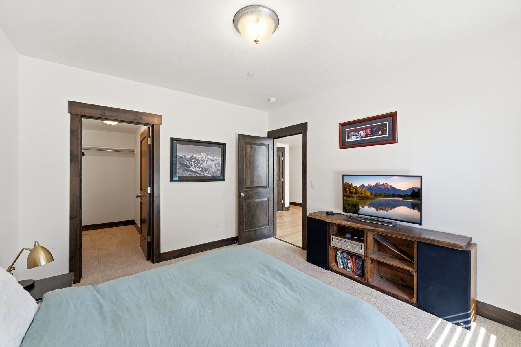 Carpeted bedroom featuring white walls, dark wood-finish trim, and a semi-flush mount ceiling light fixture