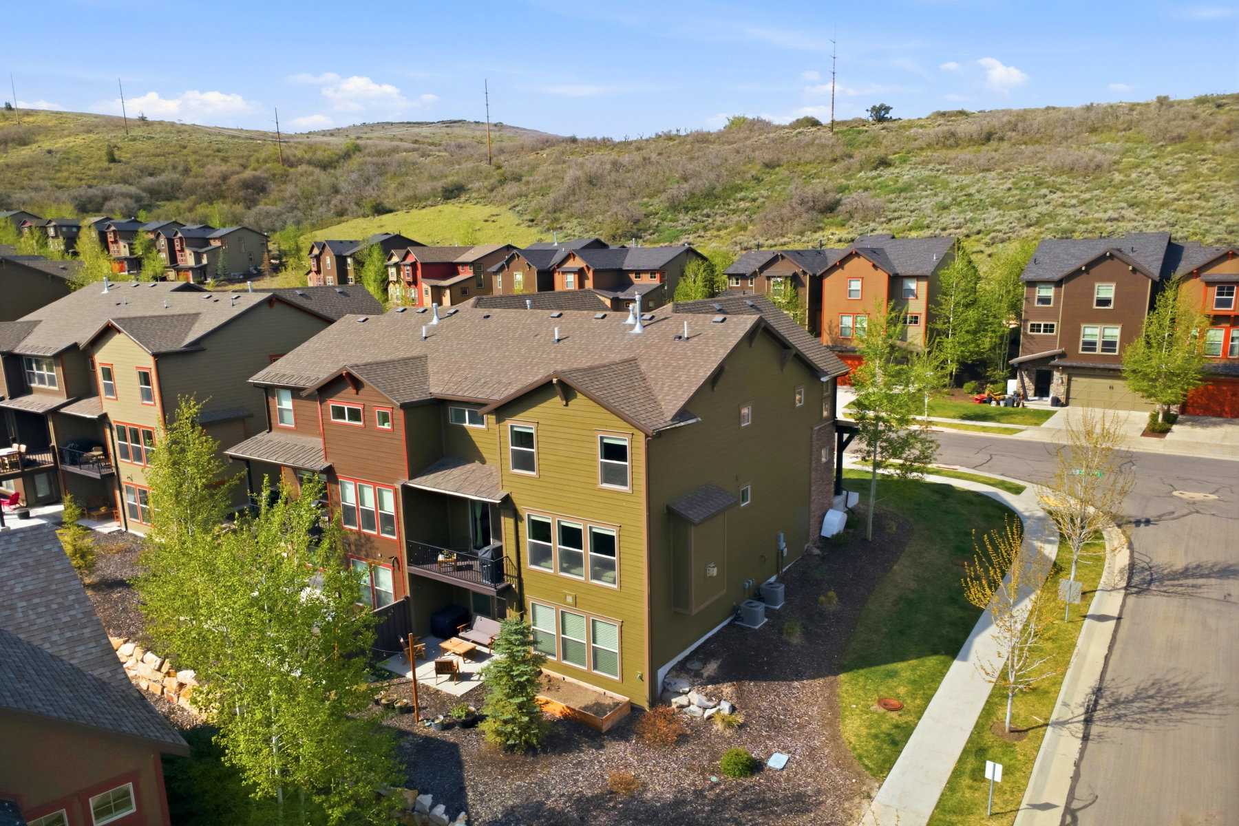 Multi-story residence featuring a multi-toned exterior with brown siding and olive-green accents