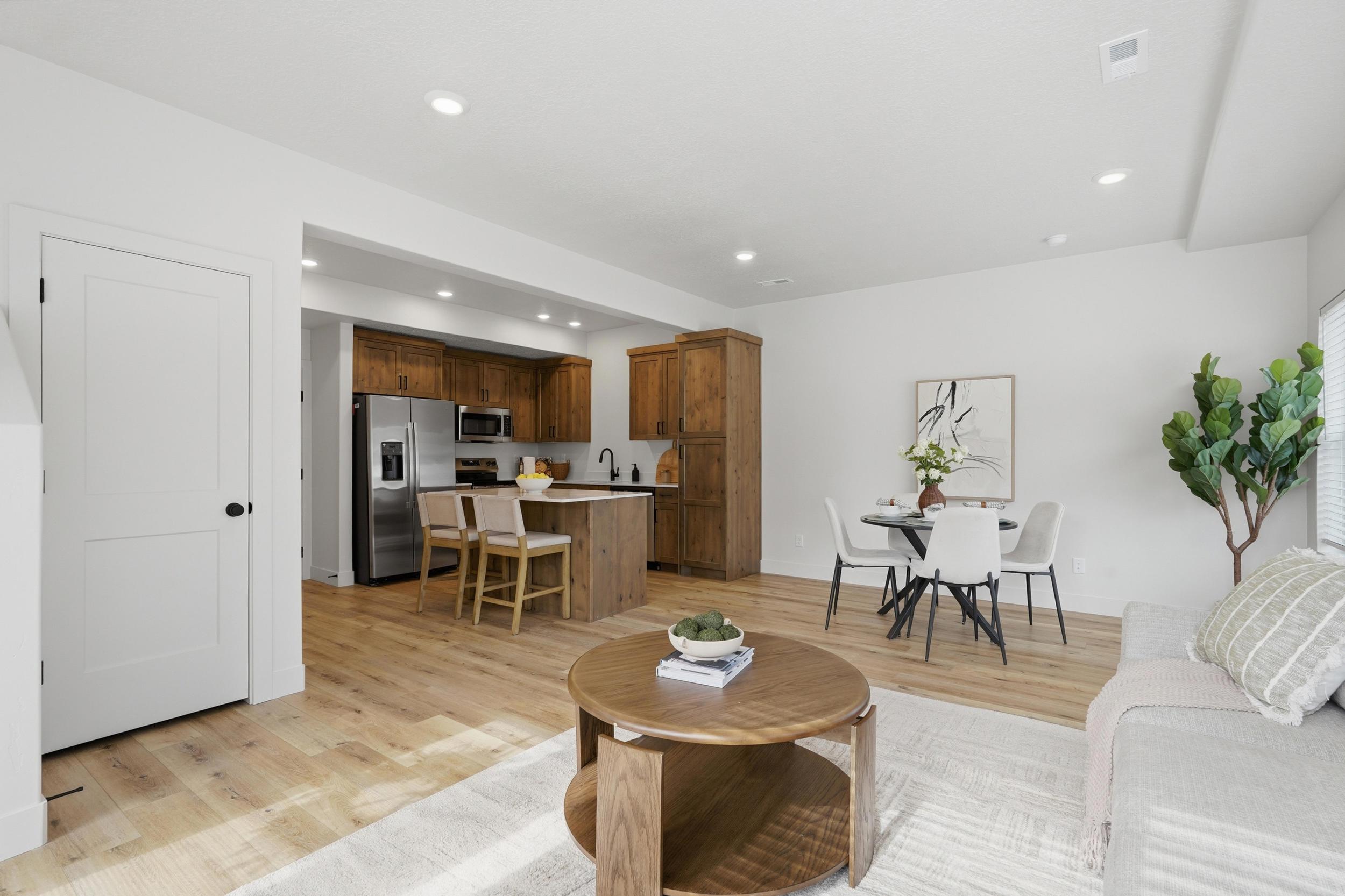 Open-concept living space featuring wood-finish flooring, recessed lighting, and white walls