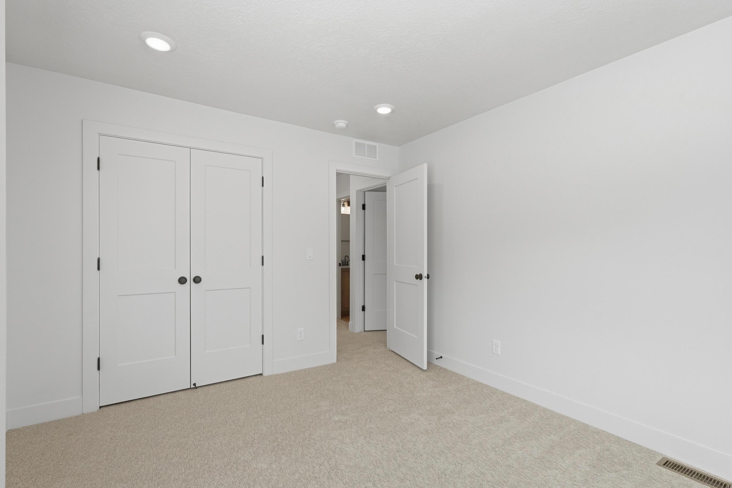 Neutral toned carpeting extending throughout, with white walls and baseboards