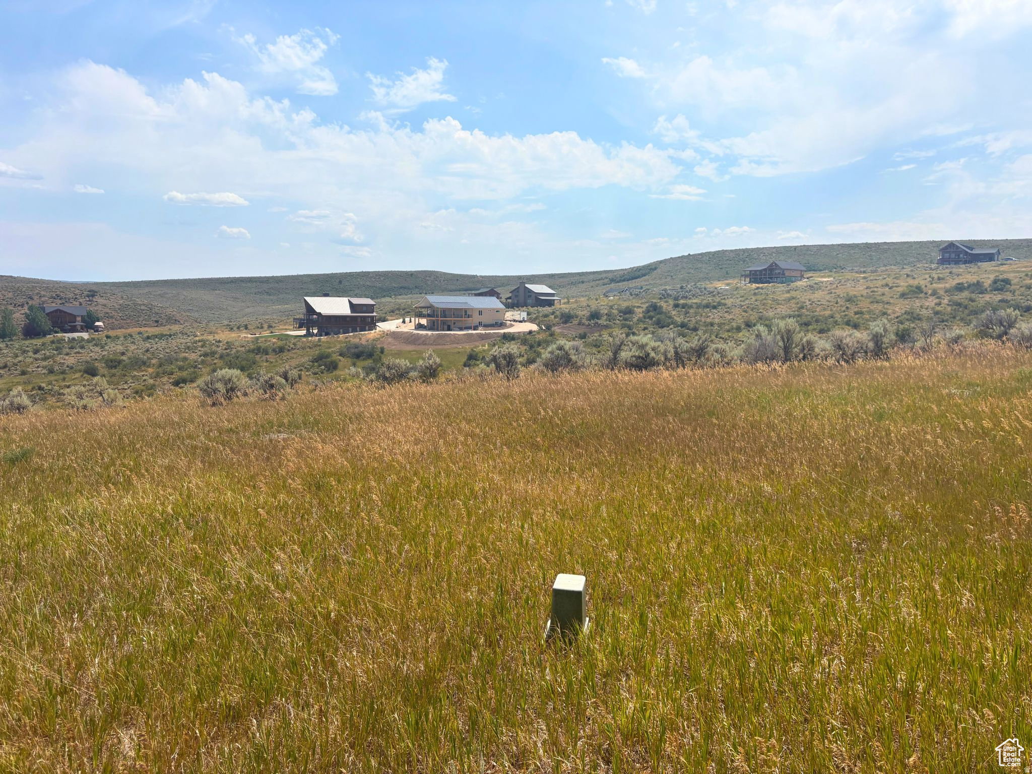 Expansive grass-covered landscape under a partly cloudy sky
