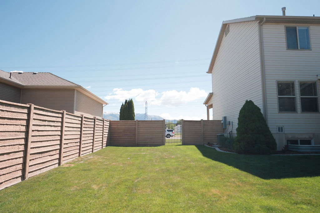 Expansive fenced yard with a manicured lawn