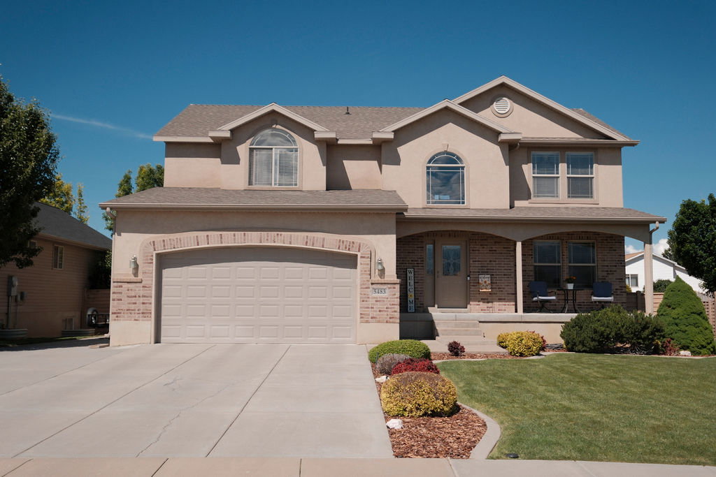 Two-story stucco and brick-front residence featuring an attached two-car garage