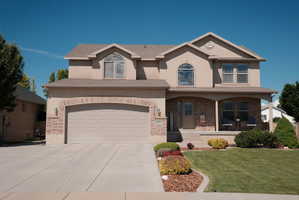 Two-story stucco and brick-front residence featuring an attached two-car garage