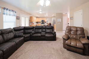 Open-concept living area featuring neutral-toned walls, textured carpeting, and recessed lighting
