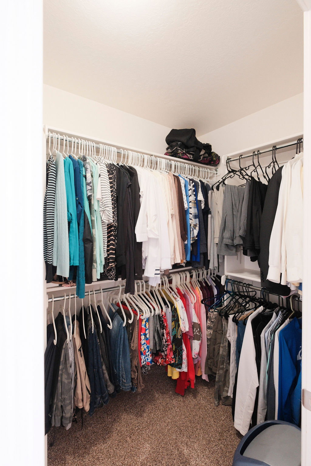 Walk-in closet featuring carpet flooring, white walls, and built-in white wire shelving with hanging rods