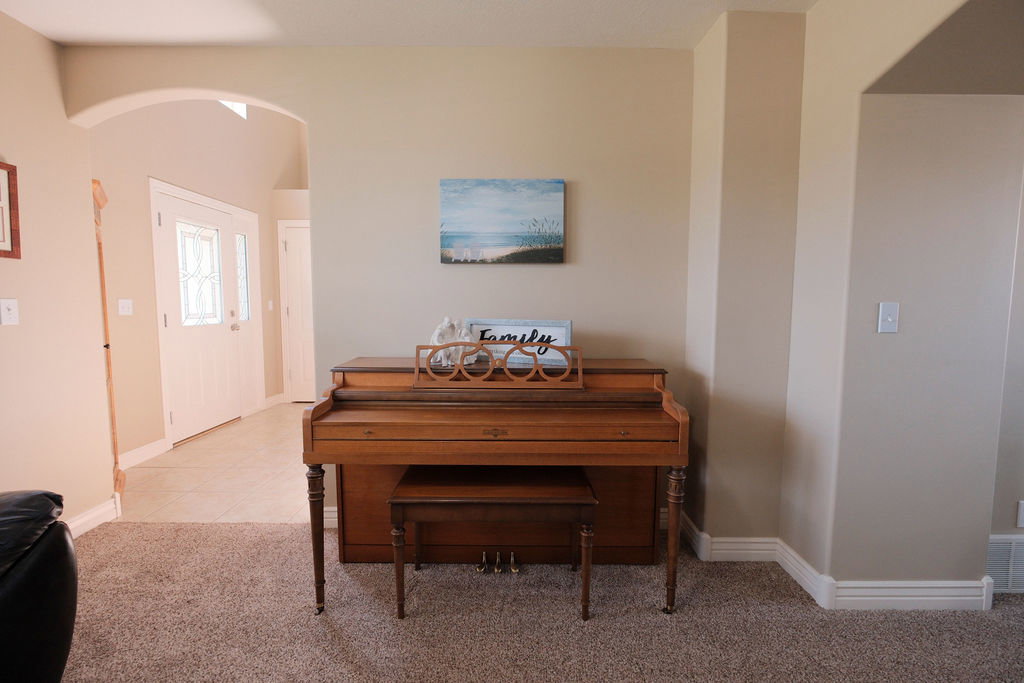 Entryway featuring an arched opening, a white front door with decorative glass inserts, and a transom window