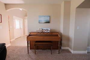 Entryway featuring an arched opening, a white front door with decorative glass inserts, and a transom window