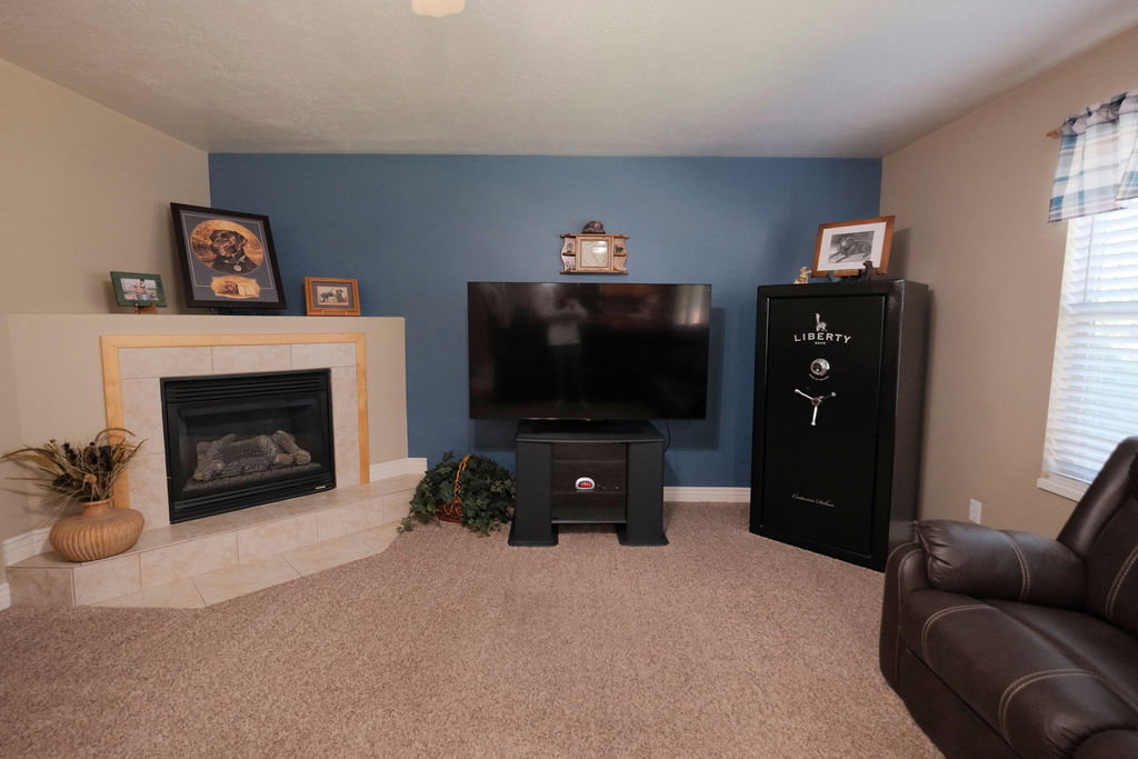 Living area featuring a corner fireplace with a tiled hearth and mantel