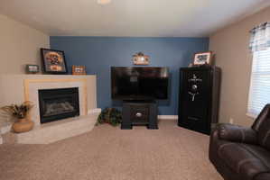 Living area featuring a corner fireplace with a tiled hearth and mantel