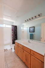 Bathroom featuring a single vanity with wood-finish cabinetry, a white countertop, and an integrated sink