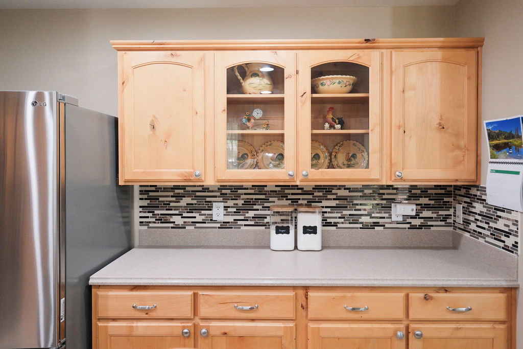 Light wood-finish cabinetry featuring both solid and glass-front doors