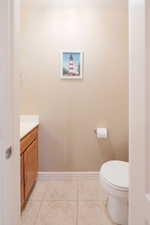 Bathroom with a built-in wood-finish vanity, white countertop, and tile flooring