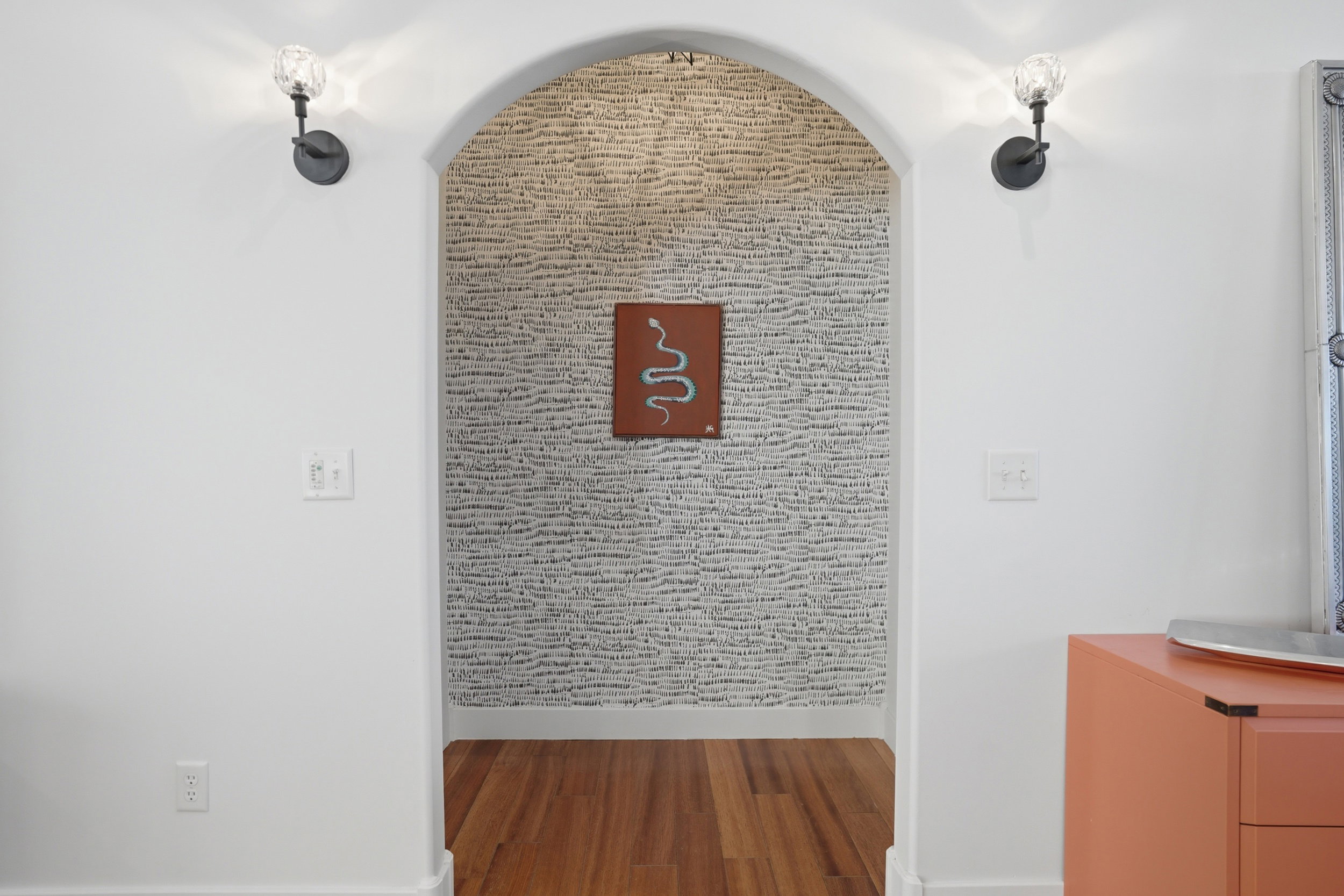 Beautiful arched entryway & wall-mounted sconce fixtures with clear glass shades. This entry way leads you to the primary ensuite with a newly remodeled bathroom and the 2nd bathroom on the main level.