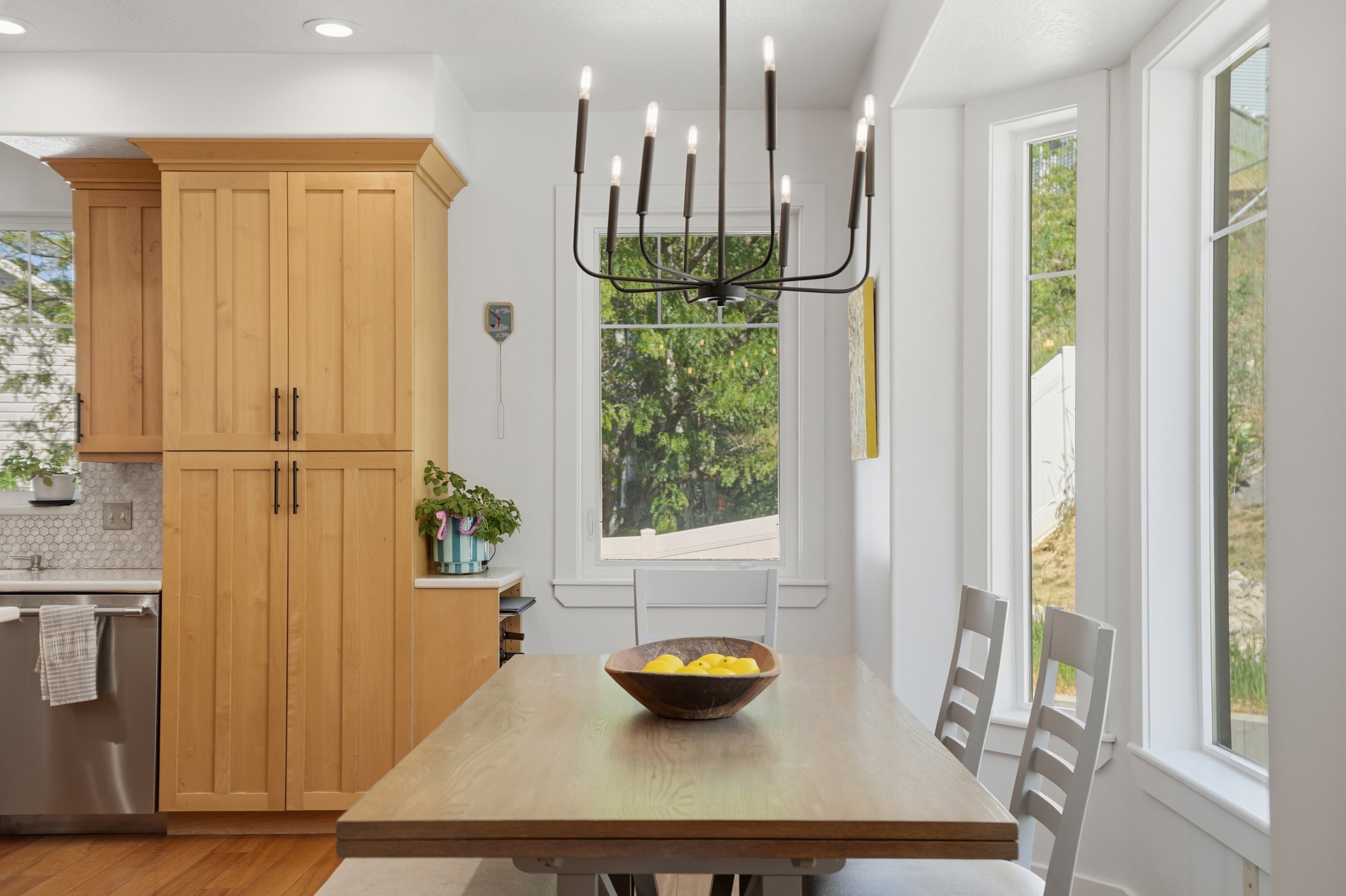 Dining area featuring a rod iron chandelier, big north-facing windows with lots of natural light.