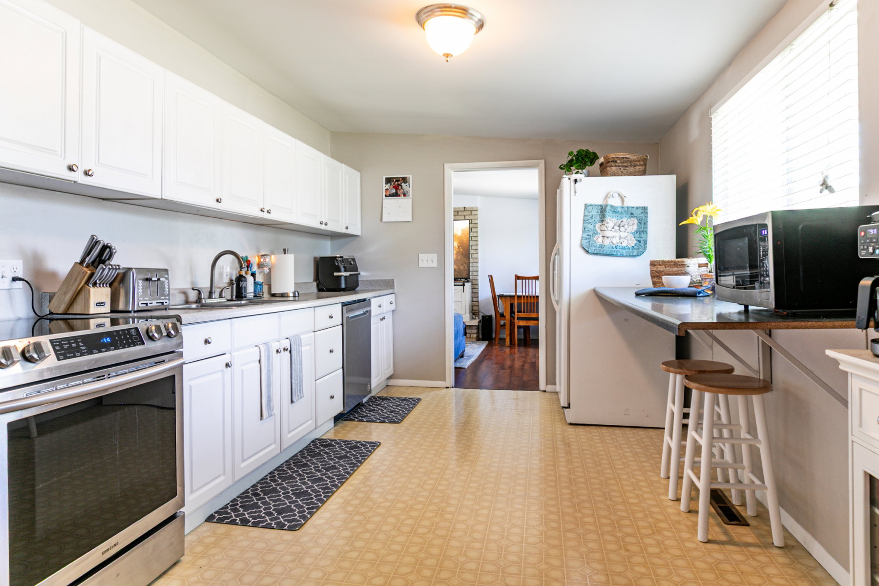 Kitchen featuring light-toned flooring and white cabinetry
