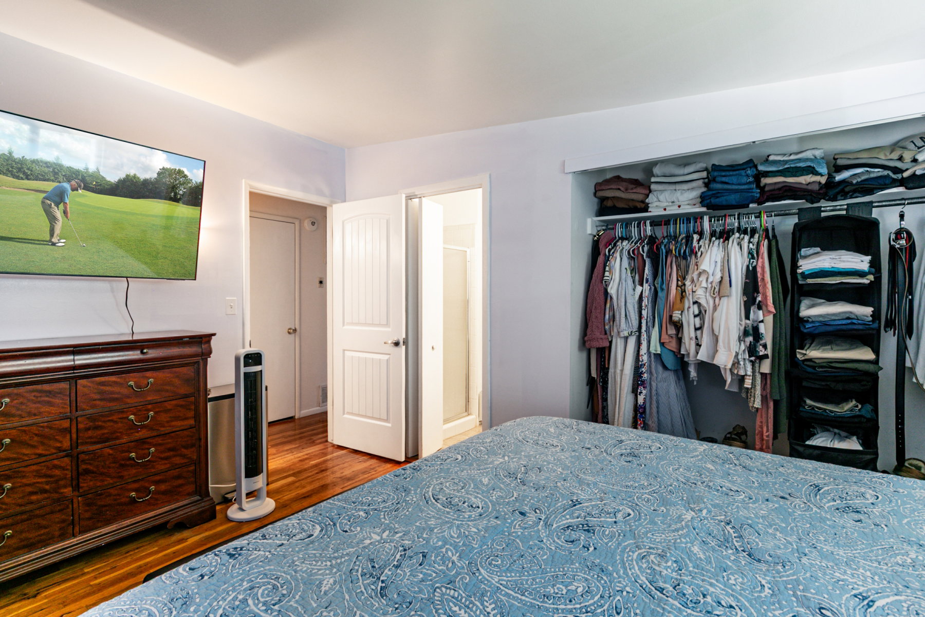 Bedroom featuring wood flooring, a large closet with king size bed