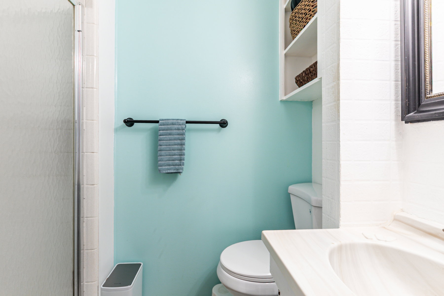 Bathroom featuring a built-in toilet, integrated shelving, and a vanity with an undermount sink