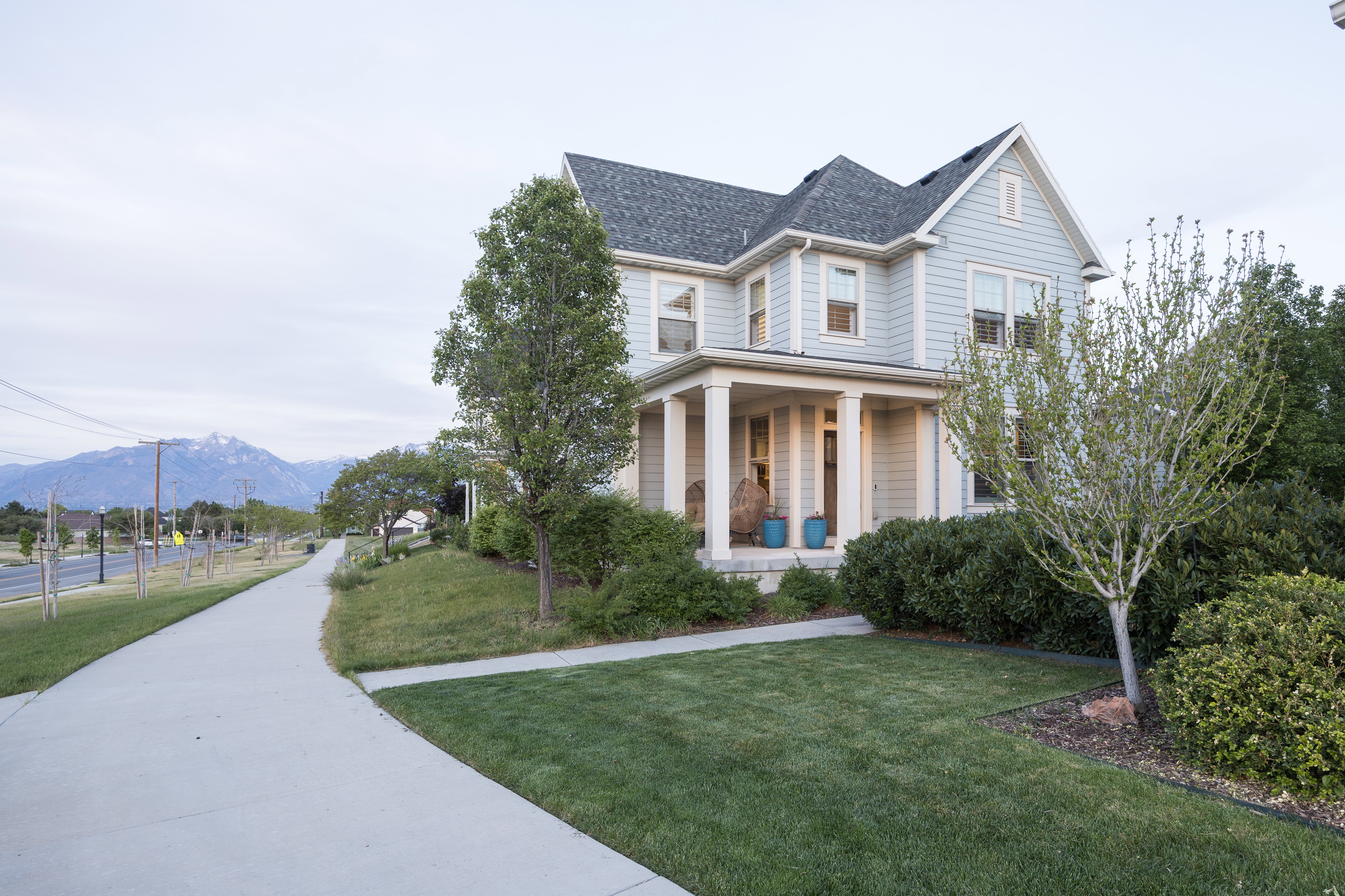 Light blue siding exterior with a covered porch featuring white columns