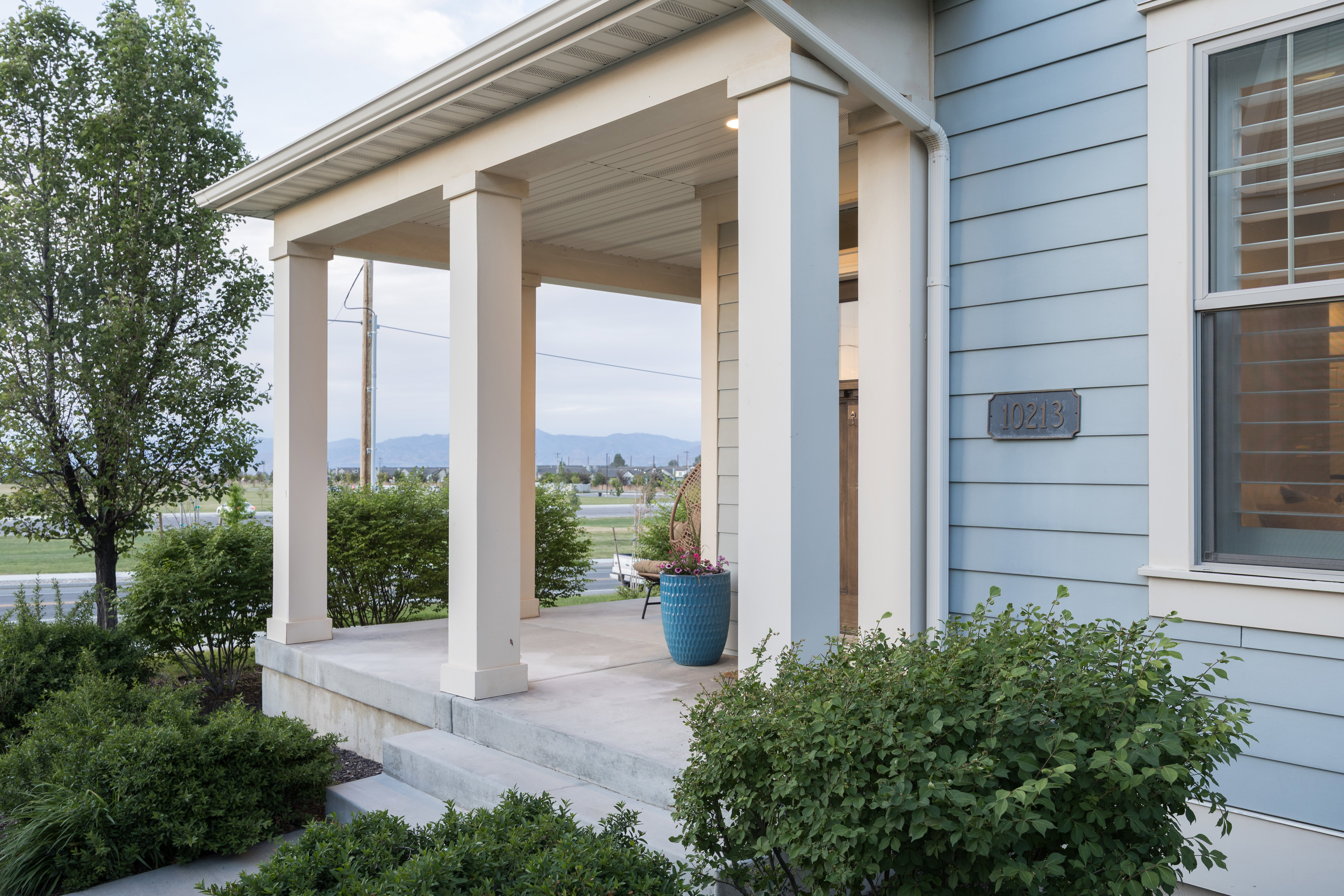 Inviting covered porch with robust square columns and a concrete entry