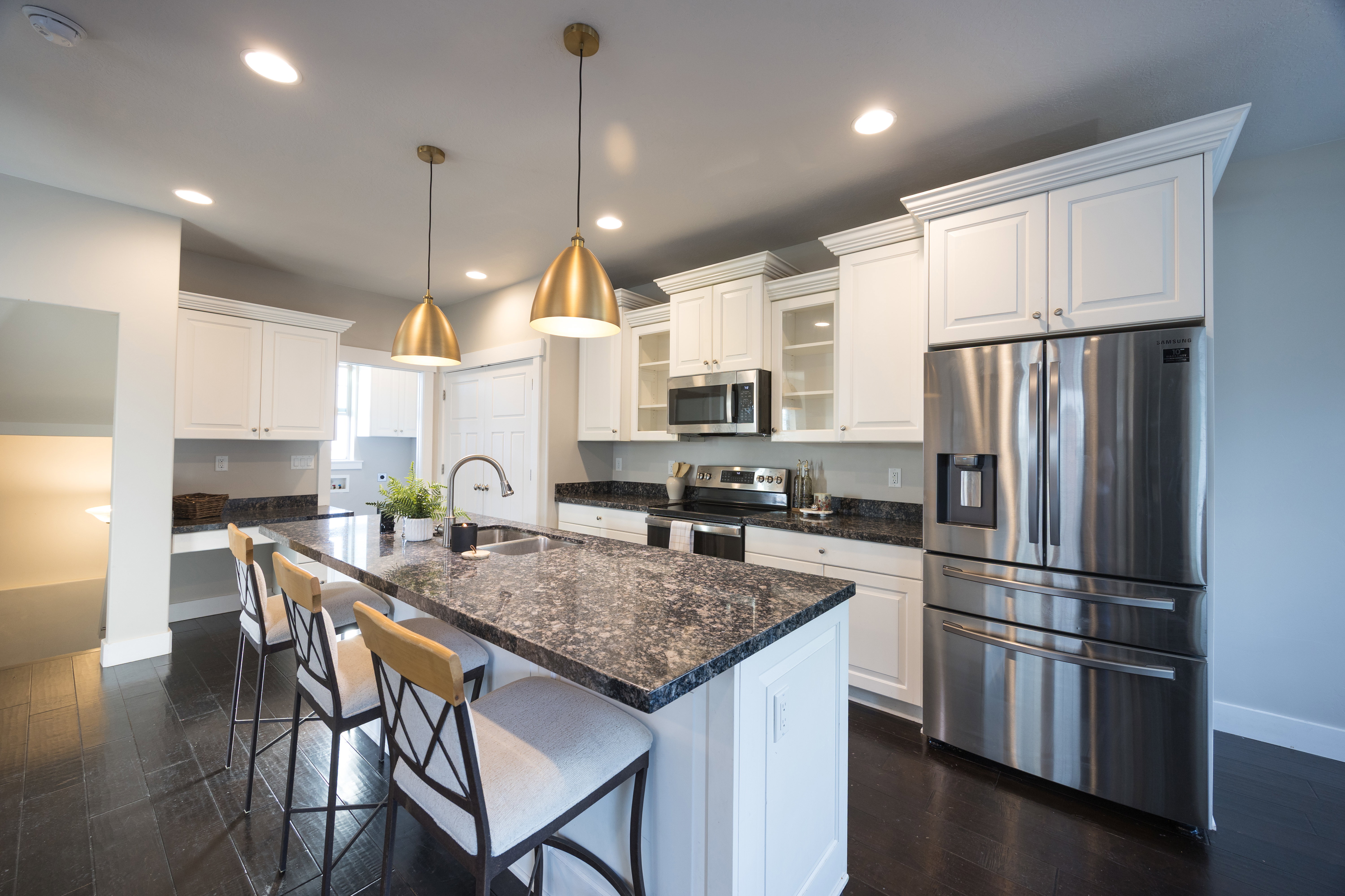 Kitchen island with stone countertop, integrated sink, and bar seating
