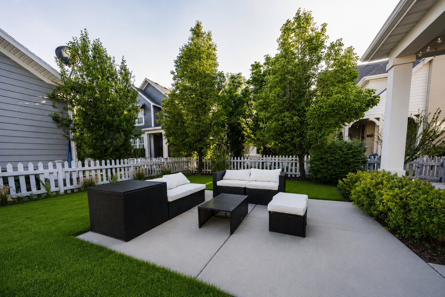Expansive concrete patio bordered by manicured lawn and mature landscaping